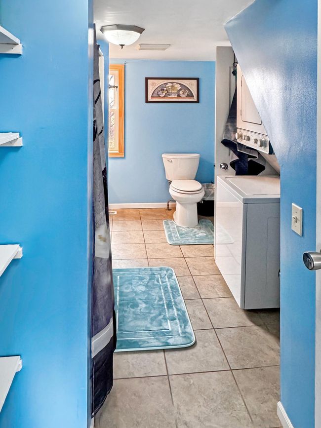 Large main floor bathroom complete with stackable washer/dryer, and tub/shower | Image 14