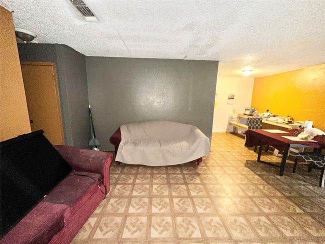 Living area with tile patterned floors and a textured ceiling | Image 24