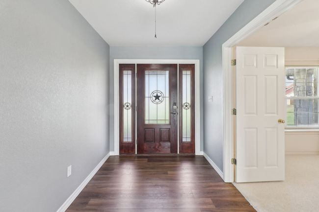 Entrance foyer featuring baseboards and wood finished floors | Image 6