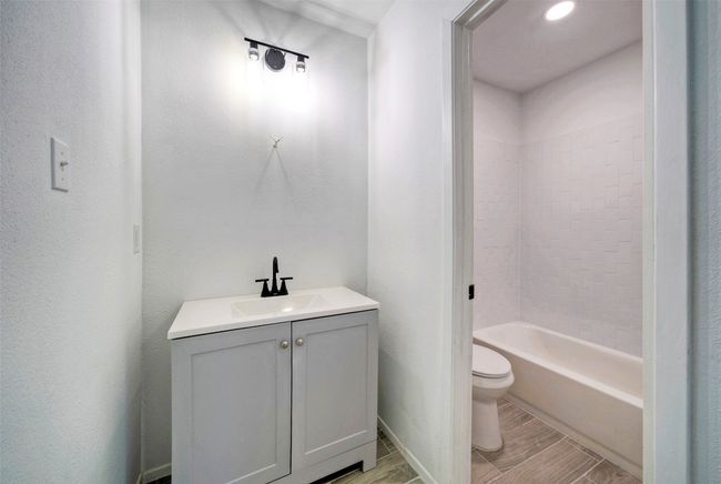 Bathroom featuring vanity, wood finish floors, and tub / shower combination | Image 13