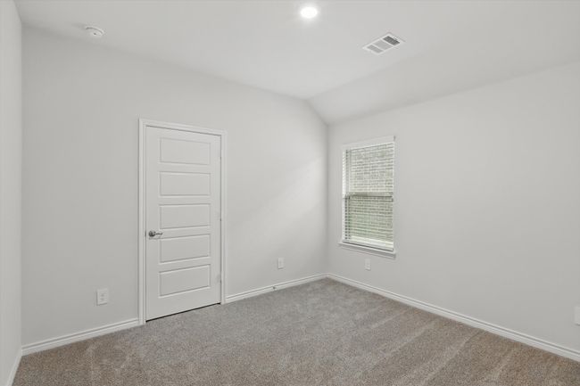 Spare room featuring carpet flooring, vaulted ceiling, and a smoke detector | Image 24