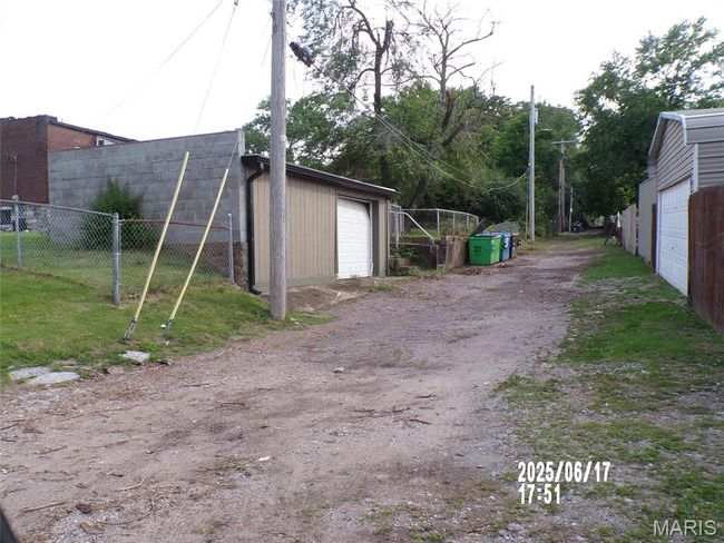 View of yard featuring a garage and an outbuilding | Image 5