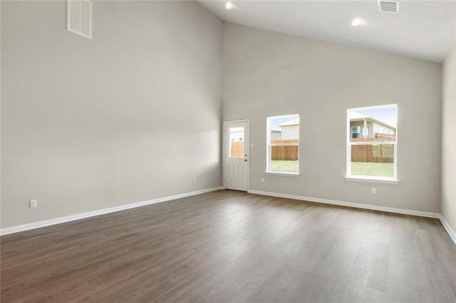 Spare room with dark wood-style flooring, healthy amount of natural light, baseboards, and high vaulted ceiling | Image 10