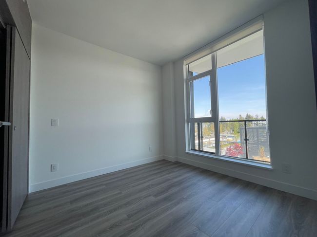 Spare room featuring baseboards and dark wood-type flooring | Image 14