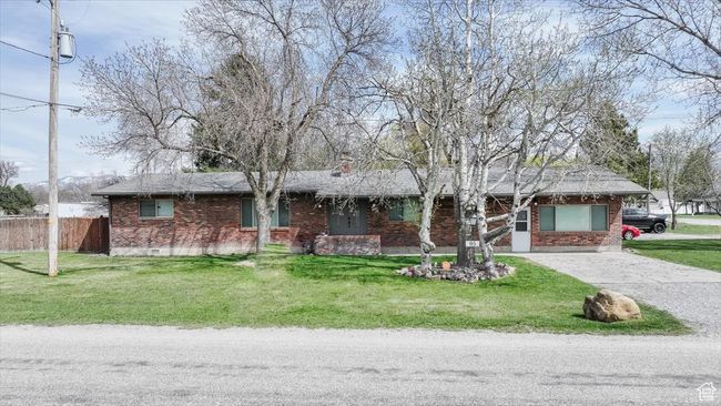 Single story home with aphalt driveway, a front yard, brick siding, and fence | Image 47
