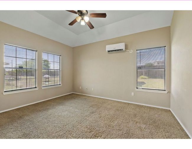 Empty room with carpet, ceiling fan, and an AC wall unit | Image 21