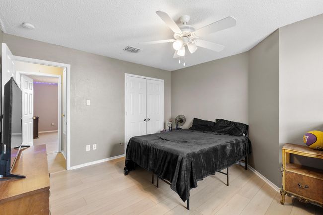 Bedroom featuring light wood-style floors, a textured ceiling, a ceiling fan, and a closet | Image 28