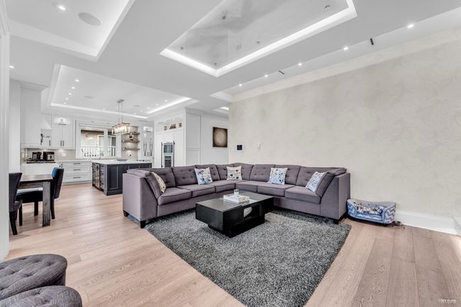 Living area featuring a tray ceiling, light wood-type flooring, and recessed lighting | Image 28