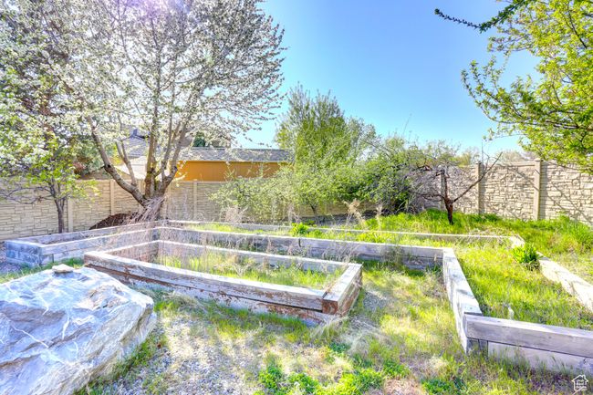 View of yard featuring a fenced backyard and a vegetable garden | Image 50
