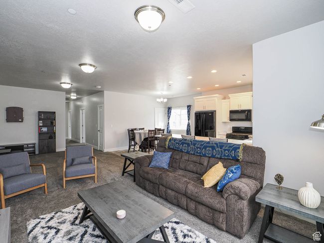 Carpeted living area with baseboards, a textured ceiling, and visible vents | Image 10