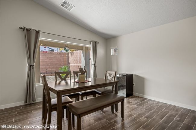 Dining area featuring wood finish floors, vaulted ceiling, baseboards, plenty of natural light, and a textured​​‌​​​​‌​​‌‌​‌‌​​​‌‌​​‌‌​‌​​​​​‌ ceiling | Image 24