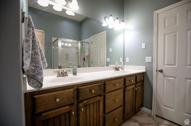 Bathroom featuring a shower stall, double vanity, and tile patterned floors | Image 25
