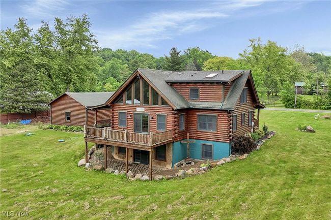 Rear view of house with log exterior, a yard, a deck, and roof with shingles | Image 46