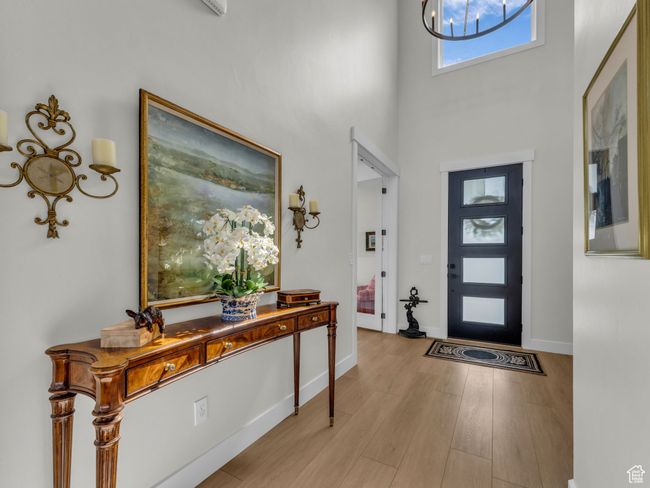 Foyer featuring a high ceiling, wood finished floors, and baseboards | Image 4