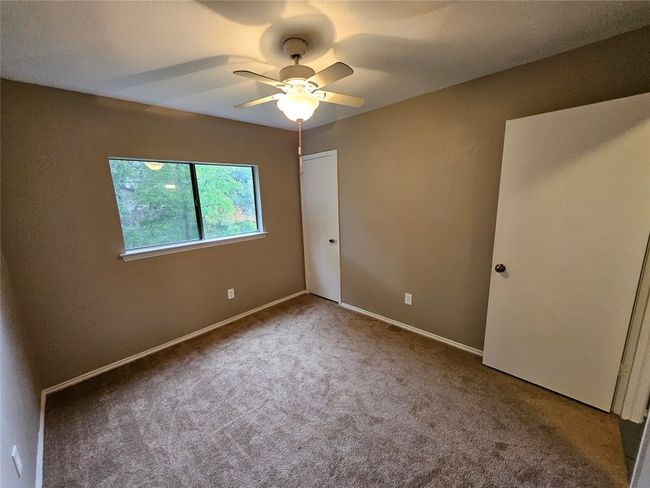 Unfurnished bedroom with a ceiling fan, baseboards, a closet, and carpet | Image 29