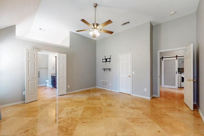 Unfurnished bedroom featuring high vaulted ceiling, baseboards, and visible vents | Image 21