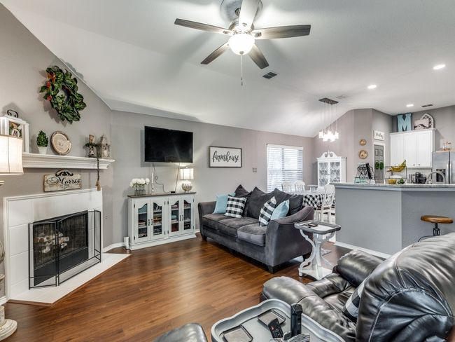 Living room featuring a ceiling fan, a tile fireplace, lofted ceiling, wood finished floors, and recessed lighting | Image 8