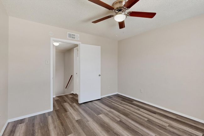 Empty room featuring a textured ceiling, ceiling fan, and wood finished floors | Image 12