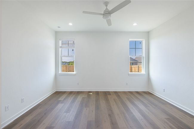 Empty room with ceiling fan, hardwood / wood-style flooring, and plenty of natural light | Image 15