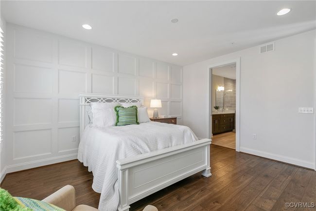 Bedroom with dark wood-style flooring, recessed lighting, visible vents, and a decorative wall | Image 21