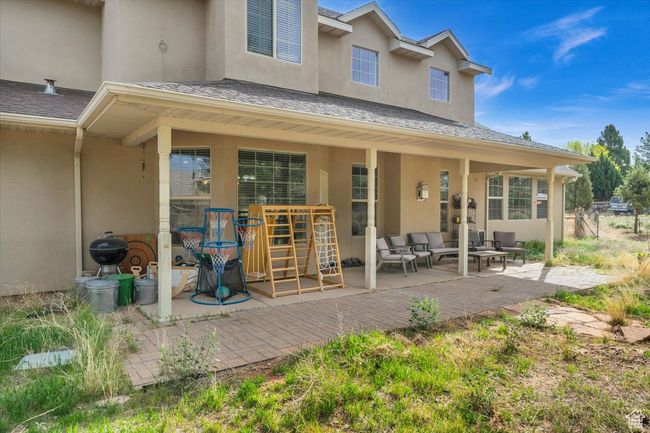 Back of property featuring a patio area, a shingled roof, outdoor lounge area, and stucco siding | Image 5