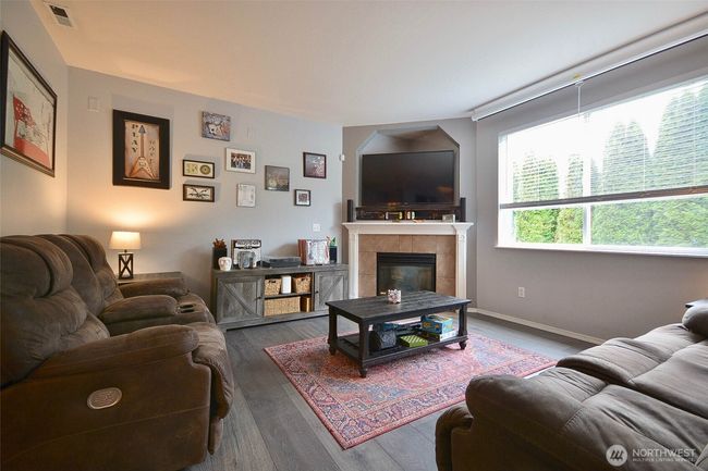 Family room with gas fireplace and tile inlay, surround system, slider to back yard. 1/2 bath and laundry room. | Image 16