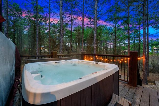 Pool at dusk featuring a hot tub and a wooden deck | Image 43