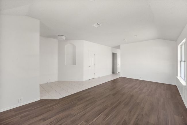 Dining room with wood finished floors, vaulted ceiling, and baseboards | Image 5