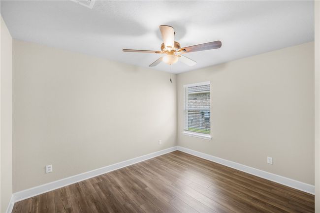 Unfurnished room with dark wood-style floors, baseboards, and ceiling fan | Image 20