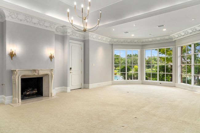 Primary suite with bay window, carpet floors, gas fireplace, chandelier, outdoor access and ensuite bathroom | Image 15