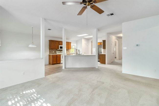 Unfurnished living room with light colored carpet, ceiling fan, and a sink | Image 19