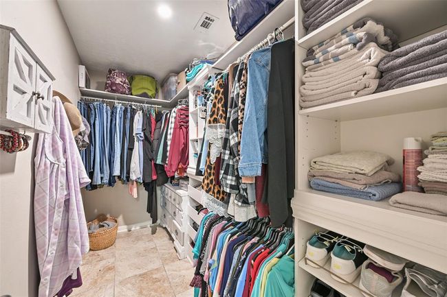Find not just one, but TWO spacious walk-in closets with custom built-ins, multiple hanging areas, and open shelving—offering generous storage and organization for wardrobes of all sizes. | Image 12
