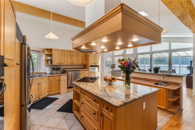 Kitchen with open shelves, a sink, beam ceiling, stainless steel appliances, and a kitchen island | Image 19