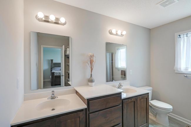 The upper level primary bath boasts a dual vanity, providing ample space and convenience for busy mornings. | Image 20