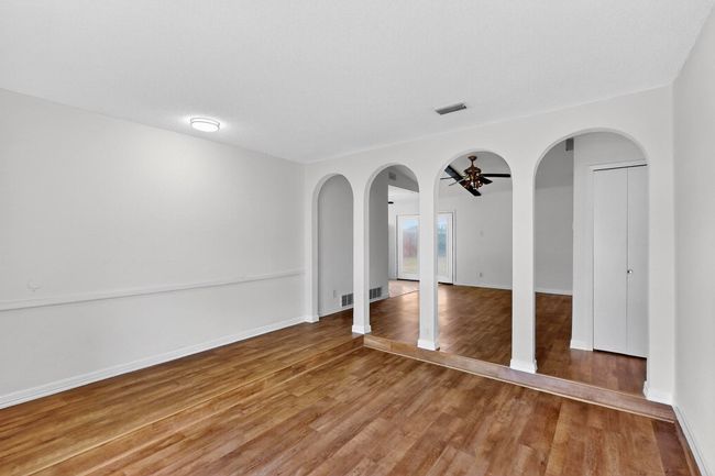 Spare room featuring ceiling fan, wood finished floors, and arched walkways | Image 6