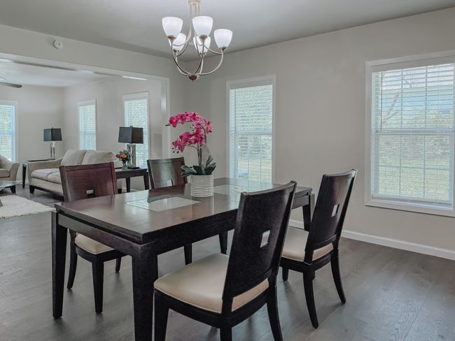 Dining space with dark wood-type flooring and a chandelier | Image 10