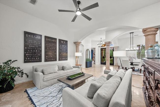 A second view of the living room showcases its size and symmetry, framed by arched entryways and easy flow into the heart of the home. | Image 11