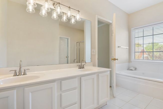 Primary bath has double vanity, soaking tub, separate shower, updated lighting and plumbing fixtures along with fresh paint | Image 17