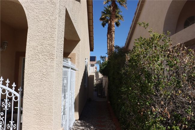 View of property exterior featuring stucco siding and a gate | Image 13