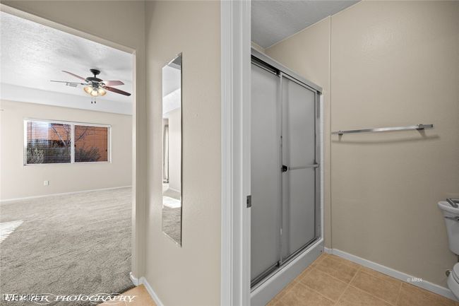 Bathroom featuring a ceiling fan, toilet, baseboards, and a shower stall | Image 30