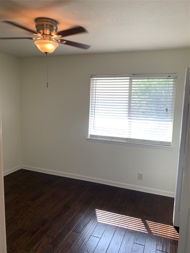 Empty room featuring a ceiling fan, dark wood finished floors, and baseboards | Image 13
