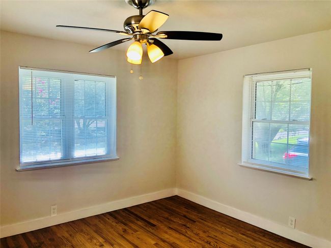 Spare room with dark wood-style floors and ceiling fan | Image 8