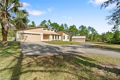 View of front facade with a front yard and a garage | Image 2