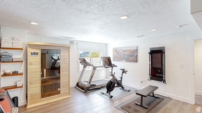 Workout area with baseboards, a textured ceiling, wood finished floors, and recessed lighting | Image 38