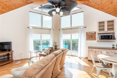 Living room with wood ceiling, ceiling fan, high vaulted ceiling, and light hardwood / wood-style floors | Image 2