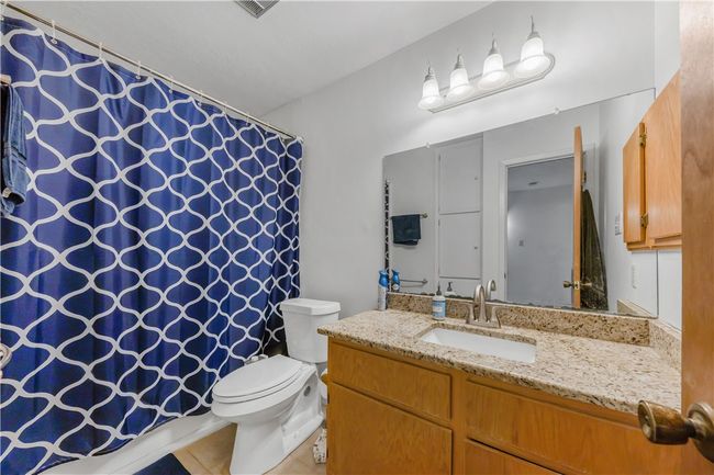 Bathroom with vanity, tile patterned flooring, and curtained shower | Image 12