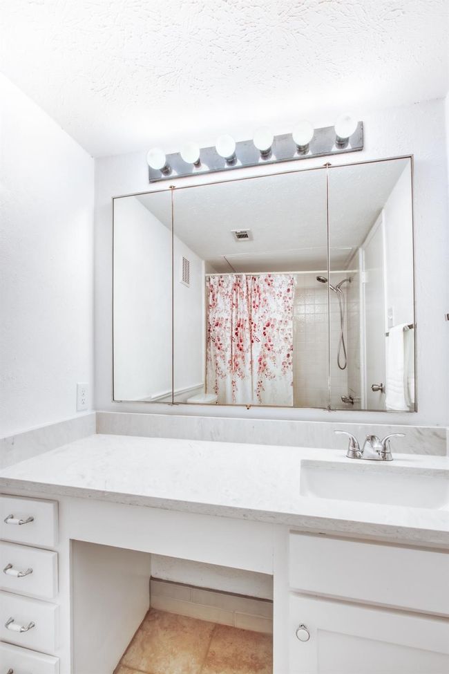 Bathroom with vanity, tile patterned flooring, curtained shower, and a textured ceiling | Image 22