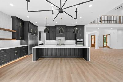 Sleek & elegant kitchen with ample cabinets, under mount and toe kick lighting. | Image 3