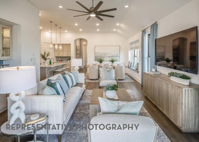 Living area featuring dark wood-style flooring, ceiling fan, arched walkways, lofted ceiling, and recessed lighting | Image 8