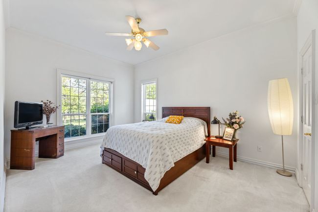 Bedroom crown molding, baseboards, and a ceiling fan | Image 24